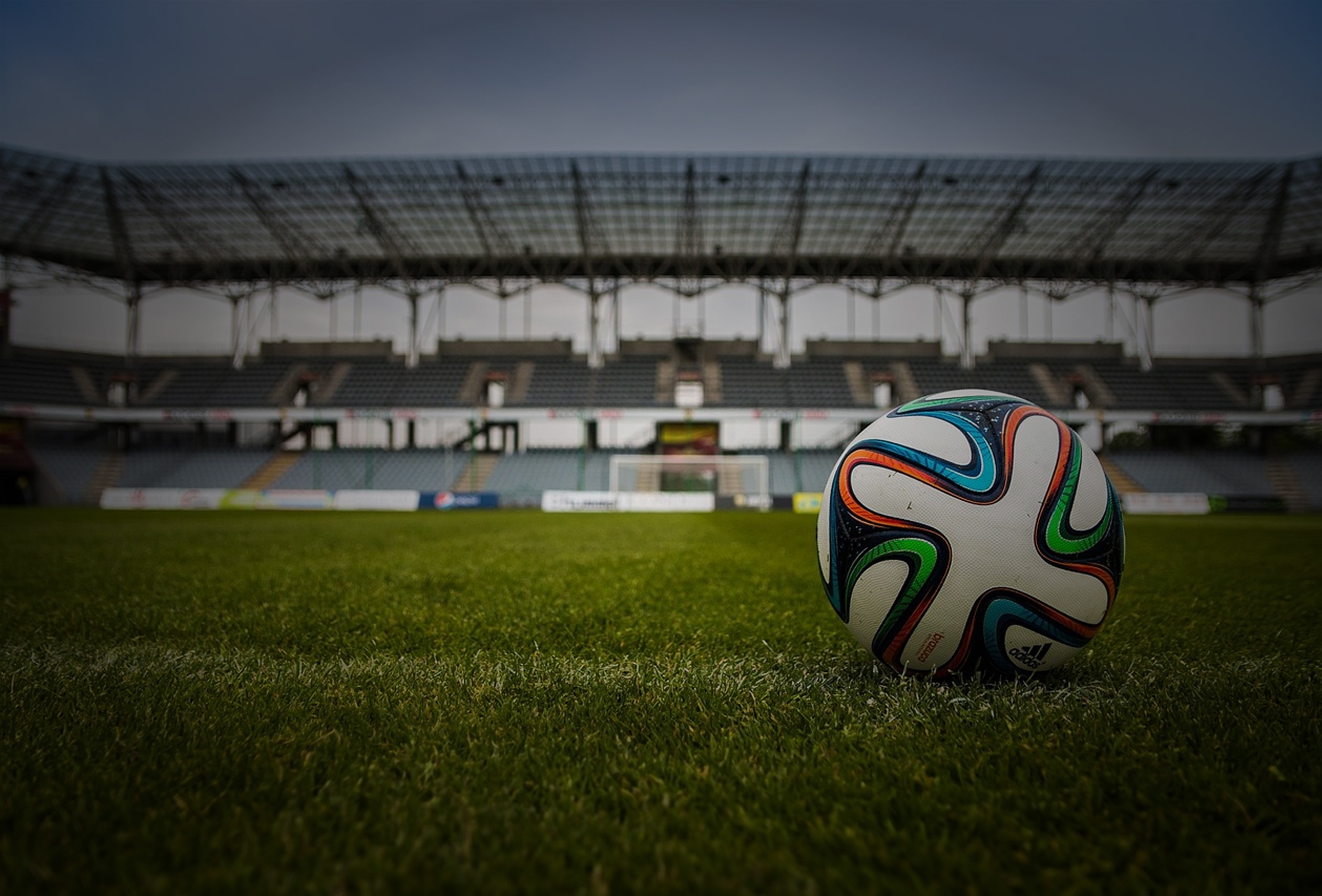 Ballon de football sur un terrain avec des gradins en arrière-plan